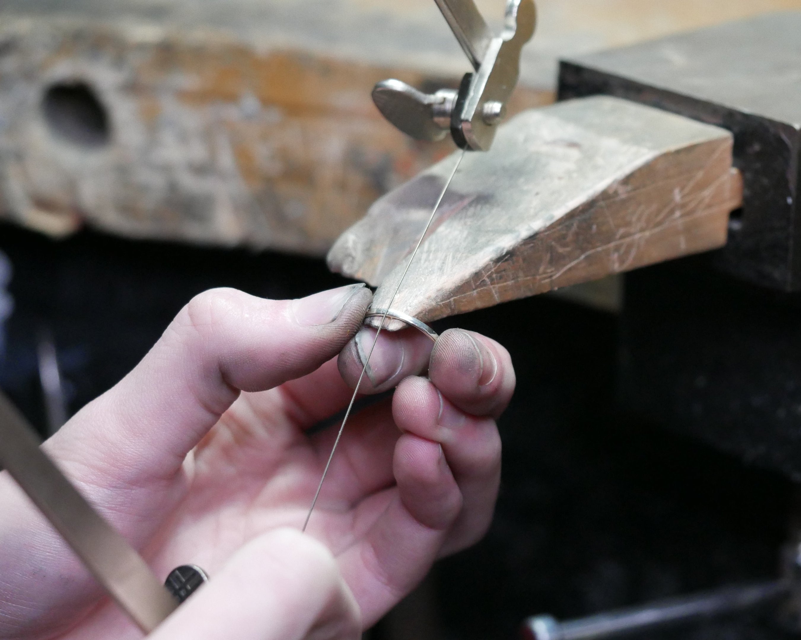Person working with metal on a anvil in a workshop setting