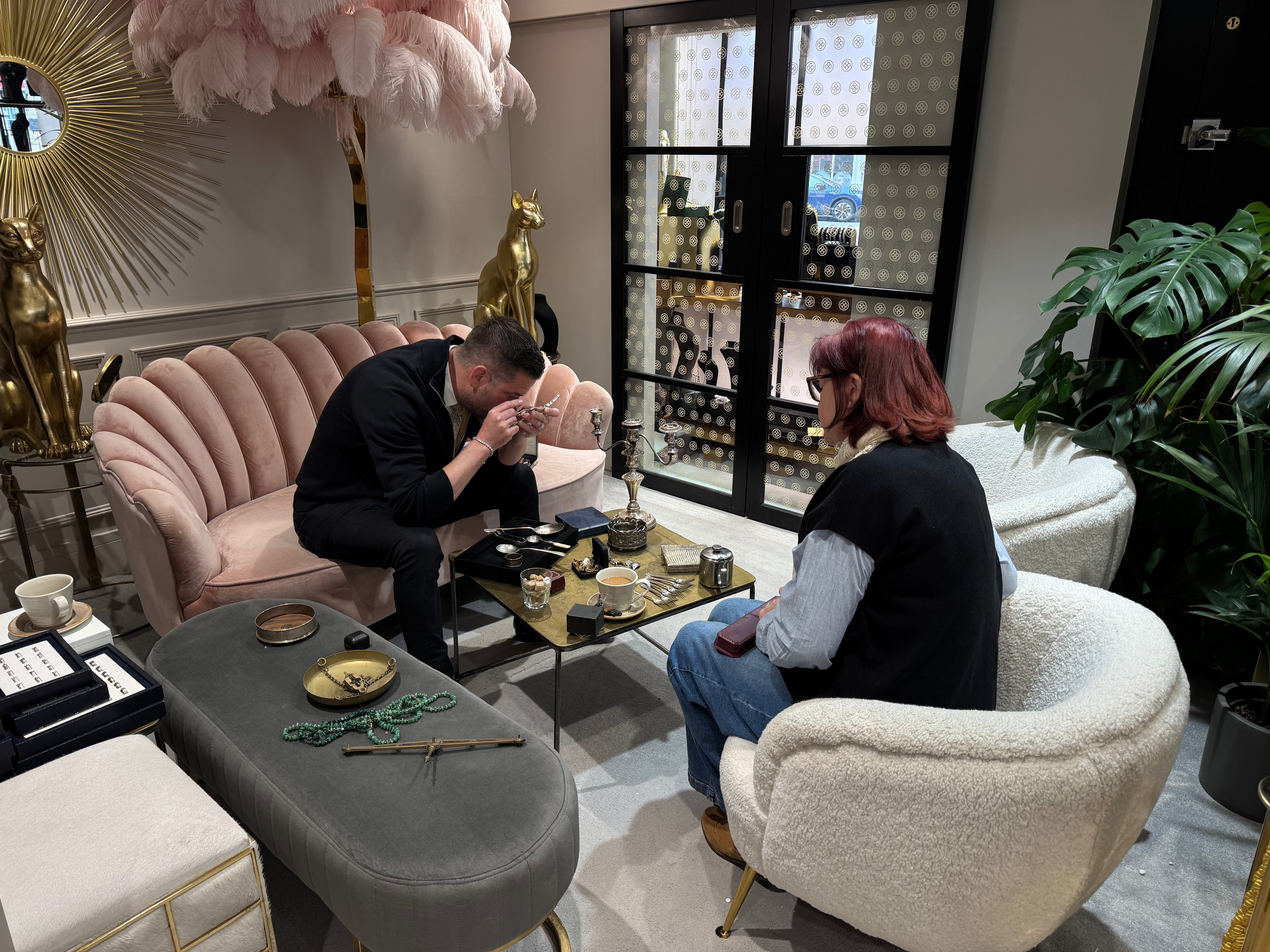 Two people sitting in a stylish living room with decorative furniture and decor.