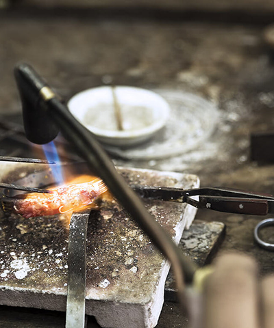 Gold being worked with a torch in the workshop